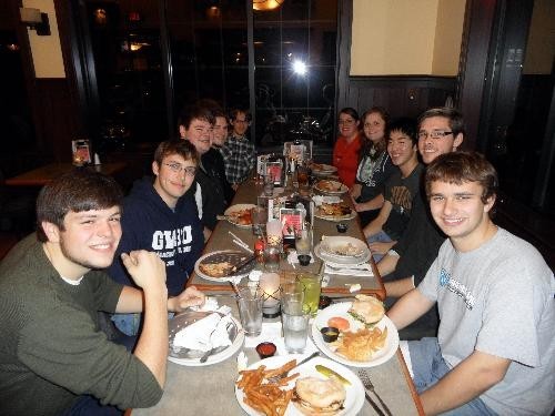 Photo of trombone students around a table sharing a meal during Fall 2011.